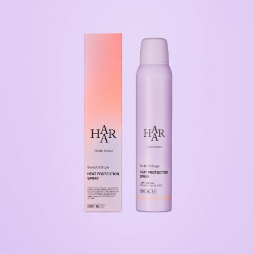 En lila sprayflaska och ett rosa förpackning för värmeskyddsspray för hår.