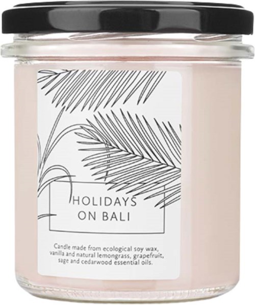 A candle jar features a white label with black palm leaves and text about Bali holidays.
