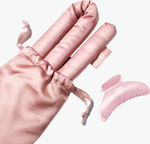 Een hand in een roze satijnen handschoen toont een kleine roze haarklem in de buurt.