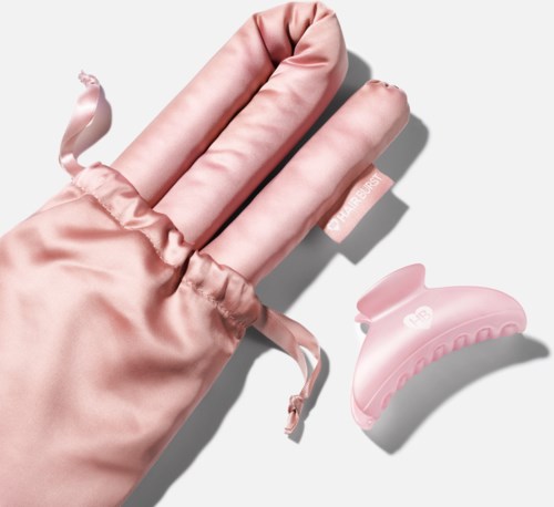 Roze satijnen handschoen en een roze haarclip met een eenvoudig ontwerp.