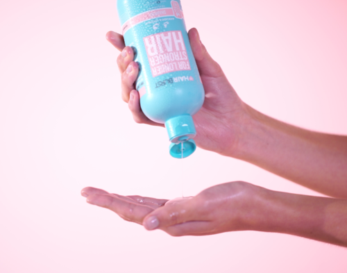 Iemand houdt een fles handenzeep vast en drukt het op de hand.