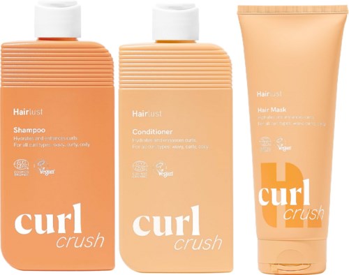 Tre hårpleieprodukter fra Curl Crush i ferskenfarge: sjampo, balsam og hårkur i tube og flaske.