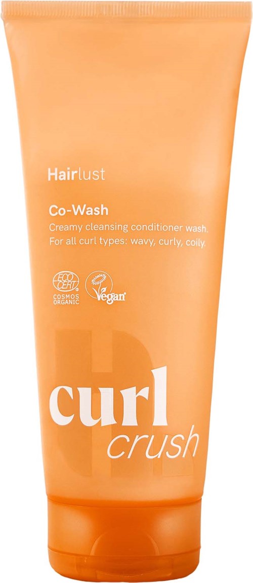 En oransje tube med Hairlust Curl Crush co-wash med produktnavn og beskrivelse for krøllete hårtyper.