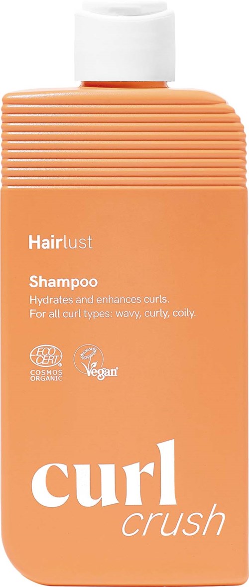 En ferskfarget flaske med Hair lust Curl Crush Shampoo og hvit kork, merket for krøllete og bølgete hår.