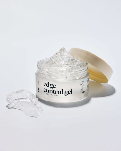 Open jar of edge control gel with some gel outside. The jar has a white label and a beige lid.