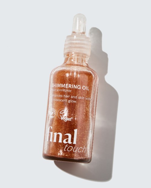 A small glass bottle of shimmering hair and skin oil with a dropper cap, labeled Final Touch, Vegan, Shimmering Oil.
