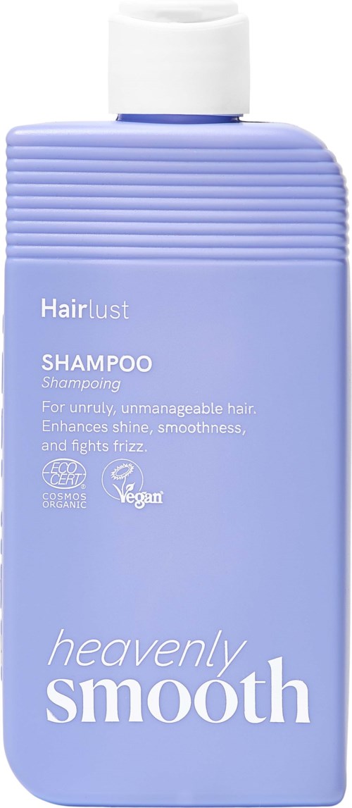 Light purple shampoo bottle with white cap, labeled Hairlust Heavenly Smooth, for unruly hair. Contains cruelty-free and vegan symbols.