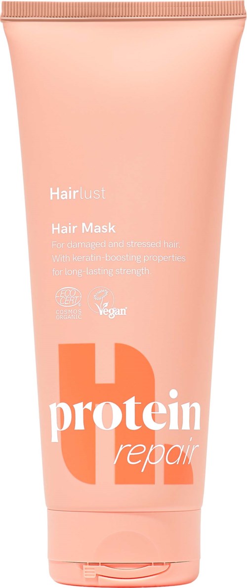 En lys rosa tube med hårkur med hvit og oransje tekst, merket for hårreparasjon og skadebehandling.