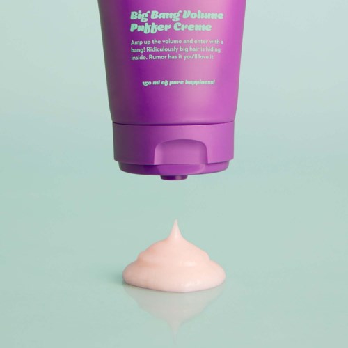 Een paarse fles met 'Big Bang Volume Puffer Creme' giet een dot roze crème.