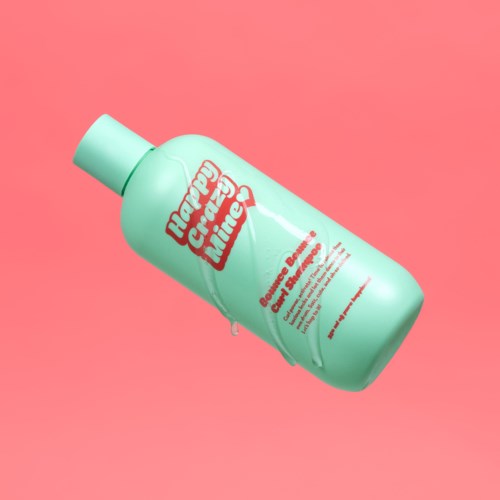Eine mintgrüne Flasche Baby Cream vor pinkem Hintergrund. Das Etikett zeigt Marke und Produktinformationen.