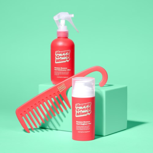 Zwei rote Haarpflegeprodukte und ein roter Kamm sind auf einer hellgrünen Oberfläche mit hellgrünem Hintergrund angeordnet.