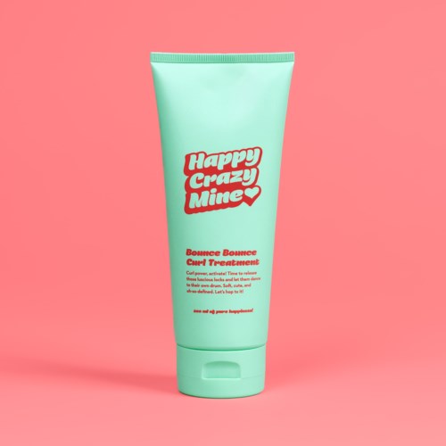Ein mintgrüner Tube mit der Aufschrift 'Happy Crazy Mine' in roter Schrift, steht vor rosa Hintergrund.