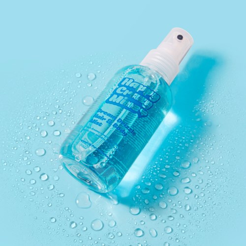 Een sprayfles met desinfecterend middel en blauwe vloeistof op een natte ondergrond.