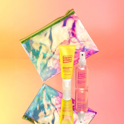 En färgglad påse och två flaskor av Happy Crazy Mind hudvårdsprodukter på en rosa bakgrund.