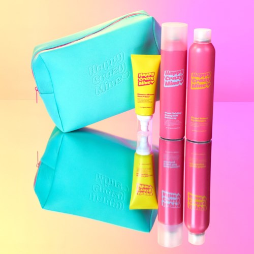 Lichtblauwe tas met roze, gele en roze flessen en een gele tube, allemaal met "Happy Creatures Mine" labels.