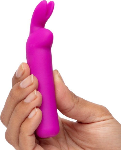 A hand holds a pink, bunny-shaped personal massager or vibrator.