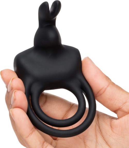 A black rabbit-shaped object with a ring at the bottom, held by a person's hand.