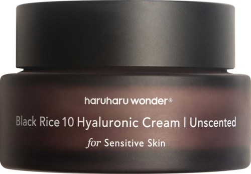Dark jar of skincare cream labeled for sensitive skin with ingredients like black rice and hyaluronic acid.