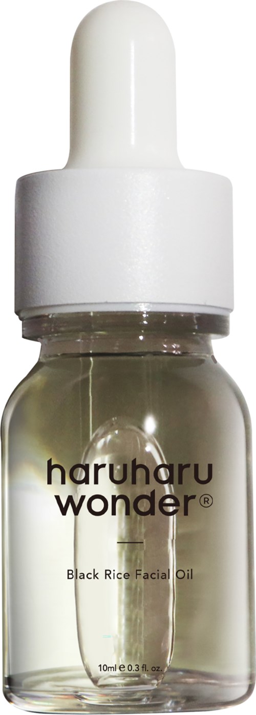 Small clear bottle with white dropper cap, labeled 'haruharu wonder Black Rice Facial Oil' for skin use.