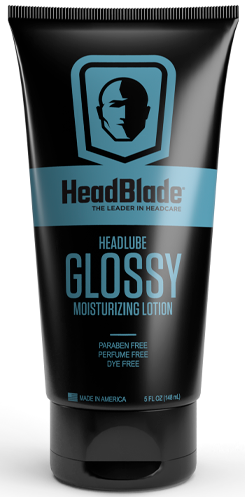 Musta tuubi HeadBlade Glossy kosteuttavasta voiteesta, sininen etiketti, kasvojen ääriviivat ja tuotetiedot.