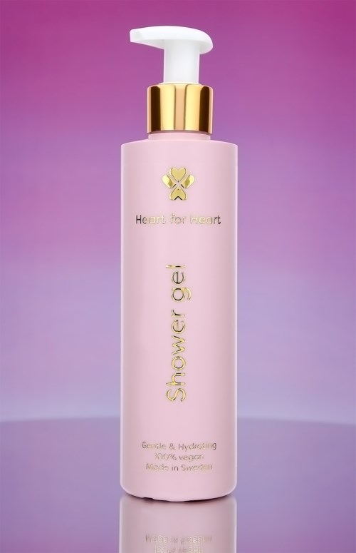 Een roze fles met pomp, gouden bovenkant en de woorden "Shower gel" en "Heart for Heart" erop.