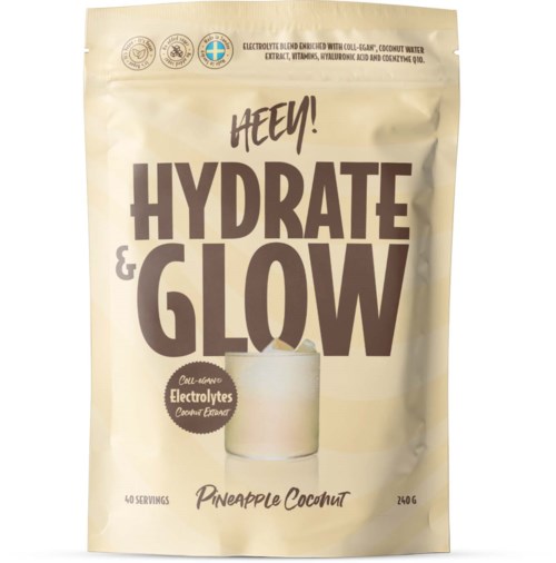 En beige pose med fet svart og brunt tekst som sier Hydrate and Glow, ananas kokos smak, med et glass av drikke.