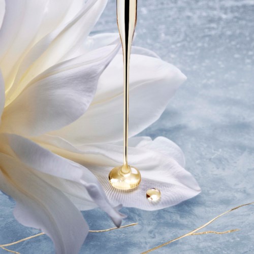 Een witte bloem met vallende gouden druppels, op een blauwe achtergrond met textuur.