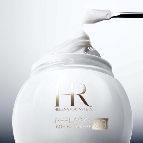 Een potje van Helena Rubinstein huidverzorgingscrème met een spatel die wat crème omhoog haalt. Eenvoudig wit ontwerp met gouden letters.