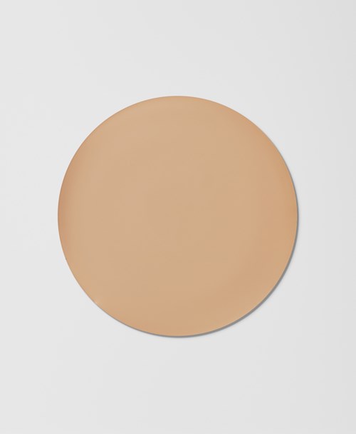 Pyöreä beige meikkilaukku, jonka pinta on sileä ja yksinkertainen valkoisella taustalla.