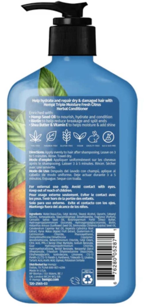 Blue shampoo bottle with green leaves and red fruit illustrations, containing hair care product with text and symbols on back.