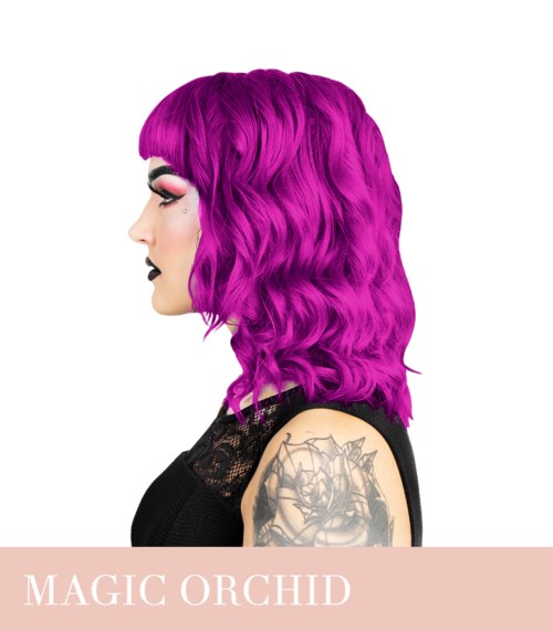 A woman with bright pink, wavy hair and tattoos on her arm, wearing dark makeup and a black top.