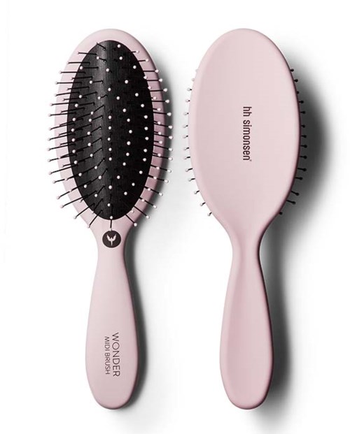 A pink hairbrush with black bristles and a cushioned base, with the words "Wonder Mini Brush" and a logo.
