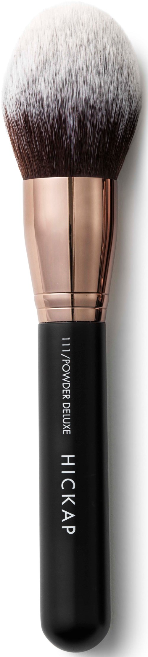 A makeup brush with a black handle, rose gold ferrule, and fluffy white bristles.