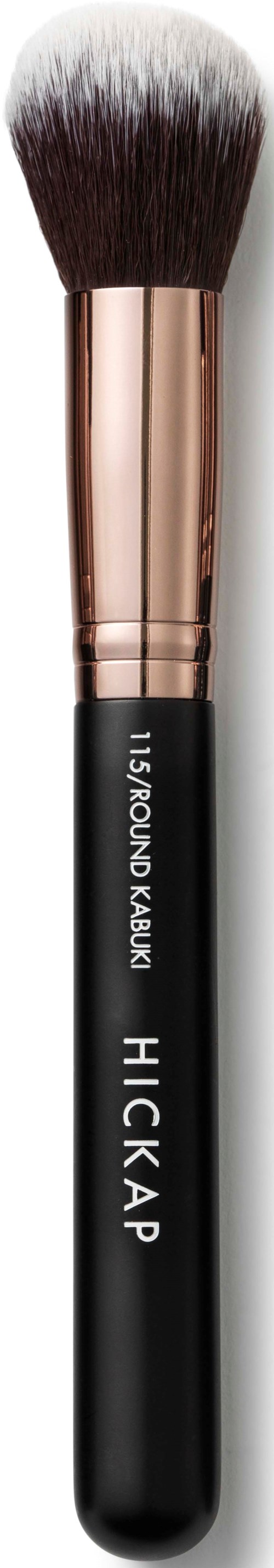 A makeup brush with a black handle, gold ferrule, and white-tipped bristles.