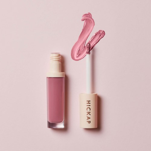 A pink lip gloss with a swan-shaped top and a pink cap with brand name 'HICKAP' on a light pink background.