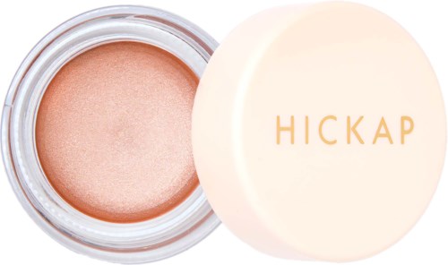 A container of peach-colored cream with a beige lid, which has the name "HICKAP" in gold-lettered text.