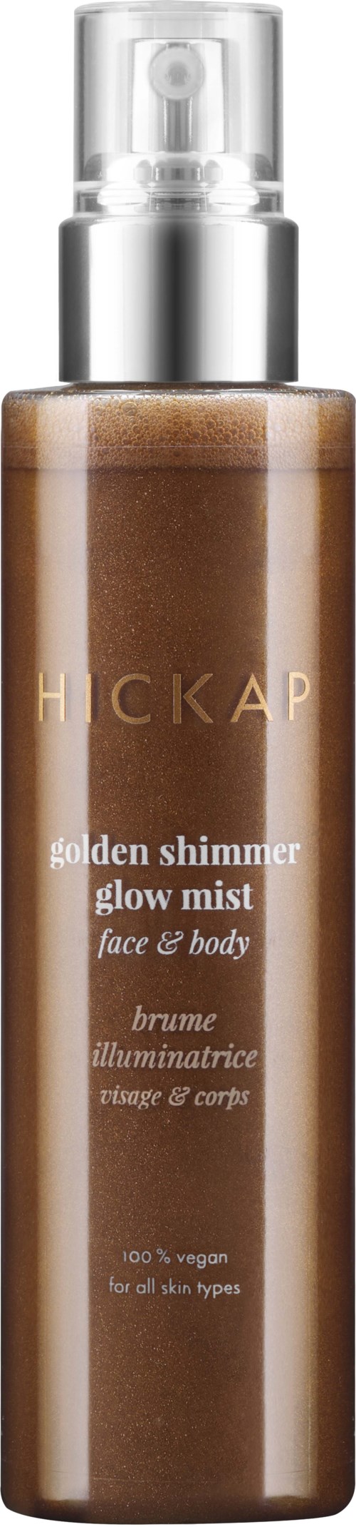 A tall, brown bottle with a silver spray top. It is labeled 'HICKAP' and 'golden shimmer glow mist' for face and body.