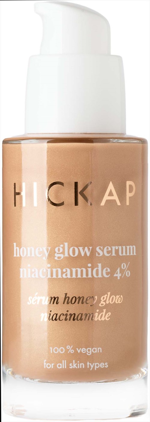 A bottle of honey glow serum with a pump dispenser, labeled for all skin types, vegan, contains niacinamide.