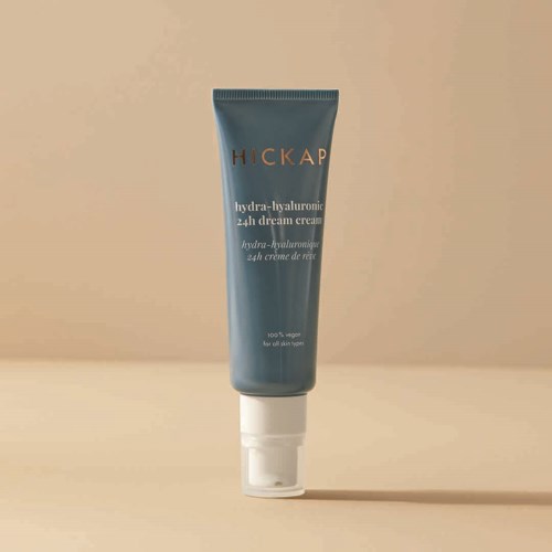 A blue squeeze tube of Hickap Hydra-Hyaluronic 24h Dream Cream on a beige background.