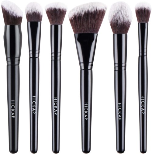 Six black makeup brushes with white tips, arranged in a row, used for applying makeup.
