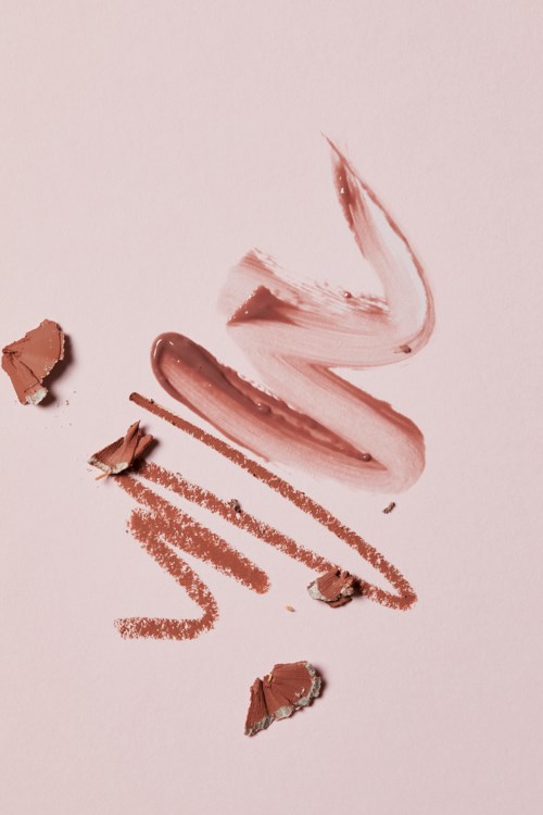 Cosmetic product swatched and broken pieces on a light background.
