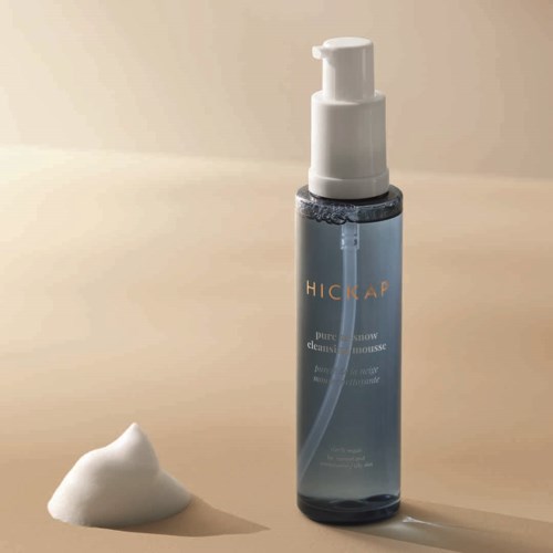 A blue bottle labeled 'HICKAP' with a pump, and a dollop of foam nearby.