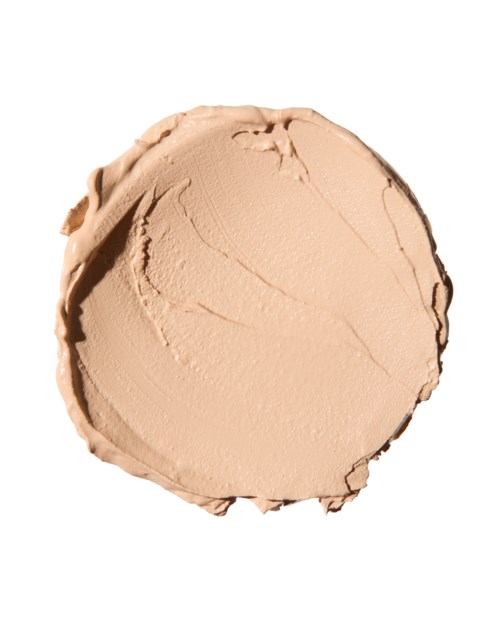Pyöreä, beige värinen massa voiteesta tai meikkivoiteesta valkoisella taustalla.