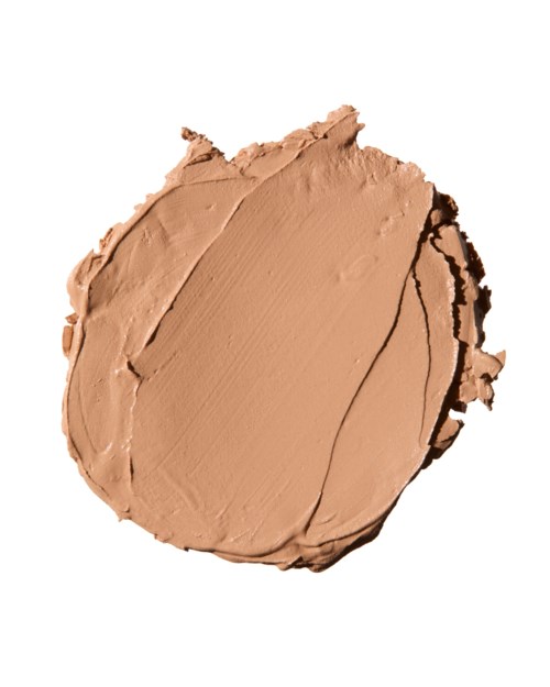 Beige kosmetiikkavoide, jossa näkyy koloja ja pieni kaari, valkoisella taustalla.