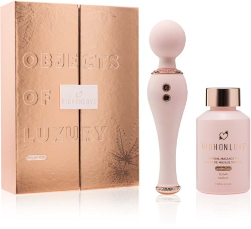 Ein luxuriöses Set mit roségoldenem Karton, weißen Massagegerät und rosa Flasche mit 'High On Love'-Beschriftung.