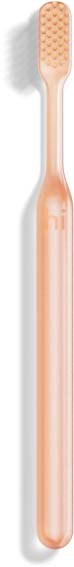 A pink toothbrush with a long handle and small, textured bristle head.