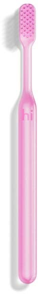 A pink toothbrush with a long handle and textured bristle head.