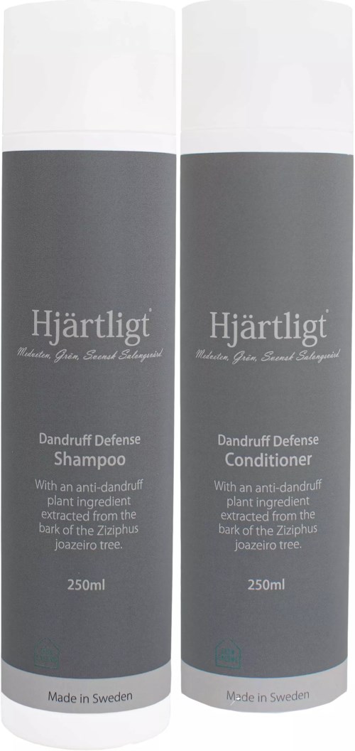 Två grå flaskor med Hjärtligt Dandruff Defense Schampo och Balsam, vardera 250 ml, med vita lock och produktetiketter.