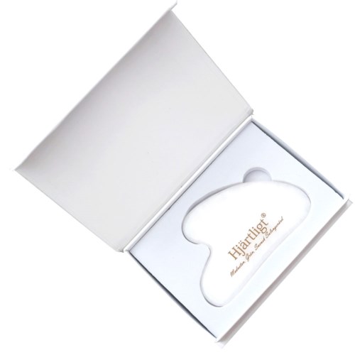 A white box with a shoulder-shaped item inside that has gold text saying 'Heartlig'.