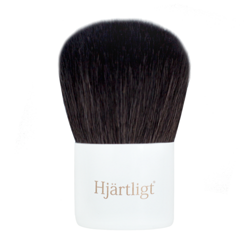 A makeup brush with dark bristles and a white handle that has the word "Hjärtligt" on it.